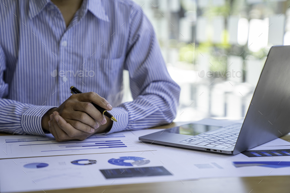 Businessman sitting at a desk financial data analysis and market growth report graph and investment