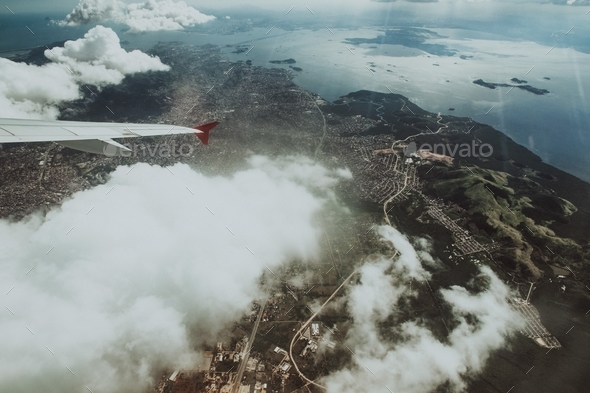 Bird\'s-eye shot from an airplane, overseeing the city with the plane\'s wing in the view