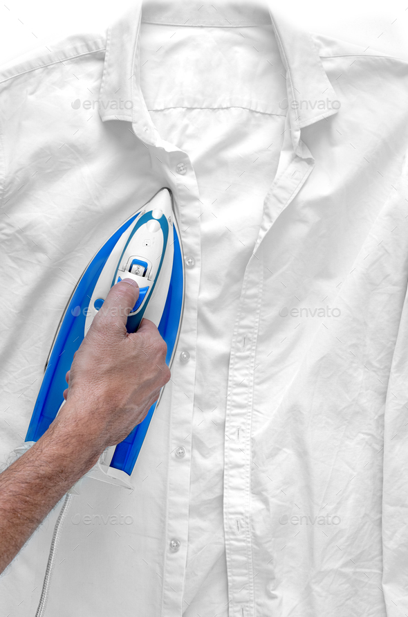 Man\'s hand irons wrinkled white shirt