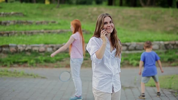 Young Woman Talking on the Phone in the Park