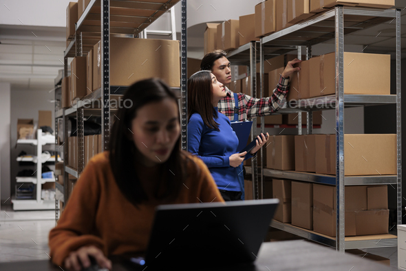 Warehouse managers processing customer order, searching box on shelf