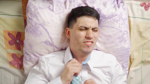 Tired After a Hard Day's Work a Man Falls Into Sofa From Powerlessness alt