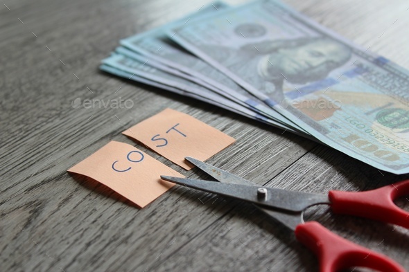 Scissor, money and note with text COST.