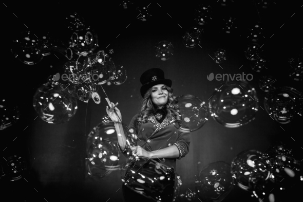 Magician lady make soap bubbles show, an illusionist in stage clothes