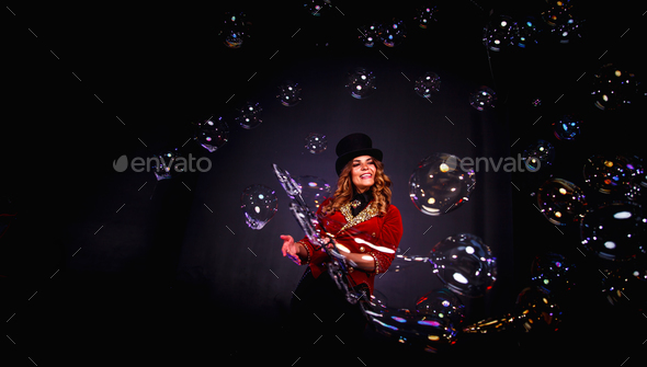 Magician lady make soap bubbles show, an illusionist in theatrical clothes