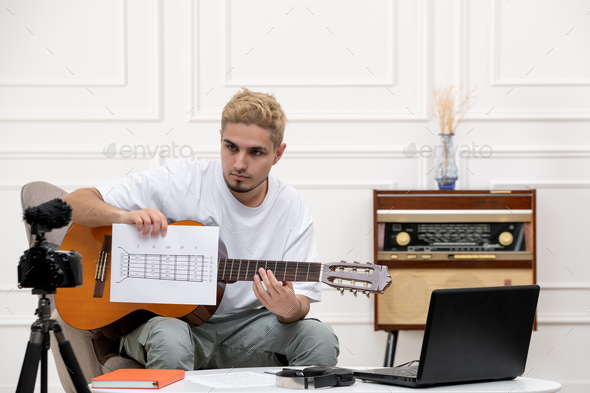elearning at home cute young handsome guy remotely giving guitar classes with musical notes