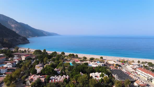 Drone shooting panoramas of a coastal city against the backdrop of the Mediterranean sea and mountai alt