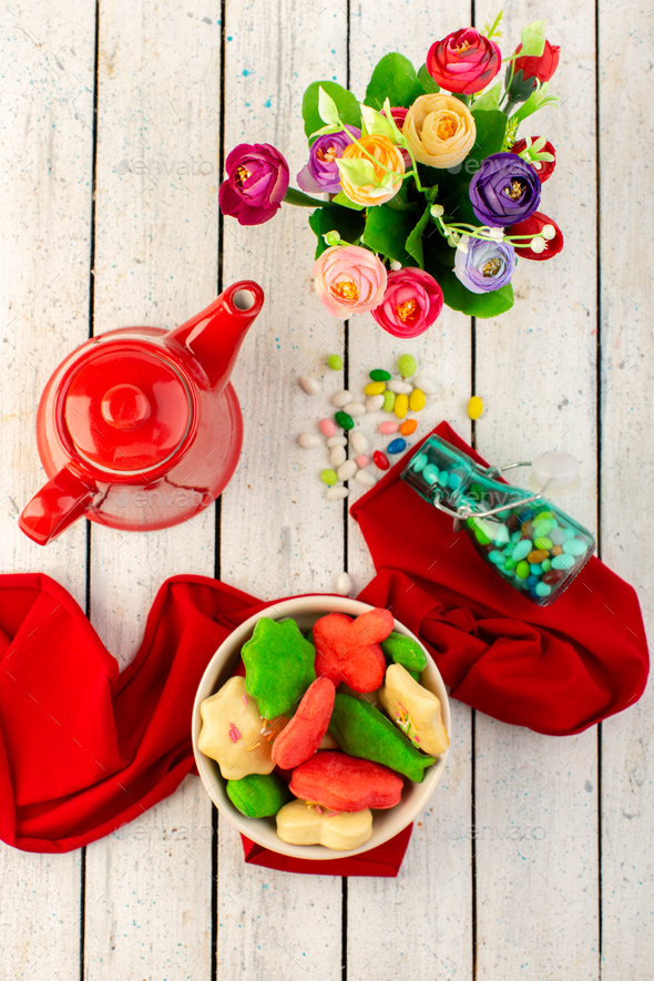 a top view colorful delicious cookies different formed inside plate with red kettle candies and