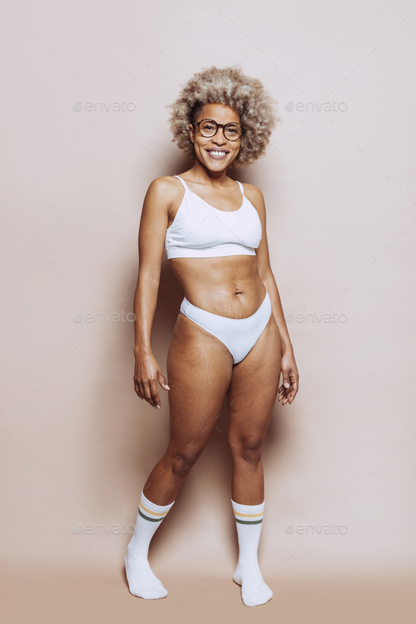 Afro woman in underwear with stretch marks on the skin at studio Stock Photo by carlesmiro