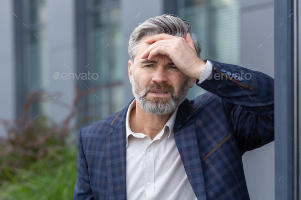 Upset and depressed boss outside office building, financial failure and bankruptcy of mature adult