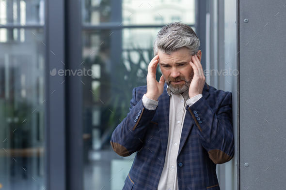 Upset and depressed boss outside office building, financial failure and bankruptcy of mature adult