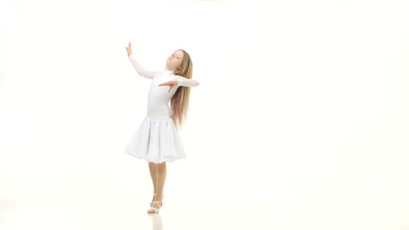Child Dances in a Beautiful White Dress on a Parquet Floor. White Background alt