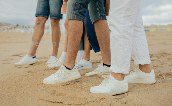 Legs of millennial diverse people in white sneakers on cropped. Active game, picnic Stock Photo by