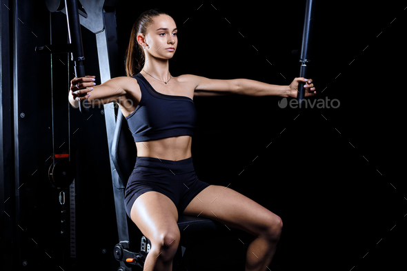 Young Determined Fitness Woman Doing Exercises at Chest Press