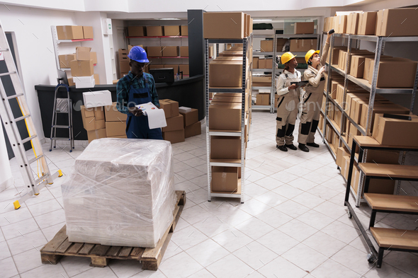 Industrial warehouse coworkers doing freight inventory, managing parcel delivery