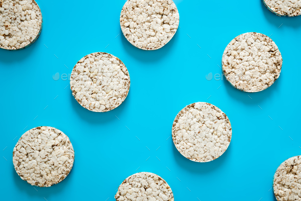 Puffed rice cakes on blue background, flat lay.