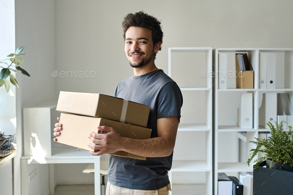Man carrying packed boxes in office