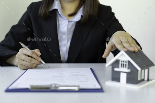 A businesswoman signing a new home purchase or sale from a real estate agent provides tax advice and