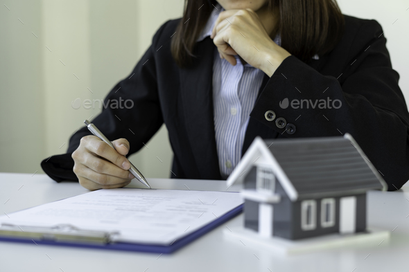 A businesswoman signing a new home purchase or sale from a real estate agent provides tax advice and
