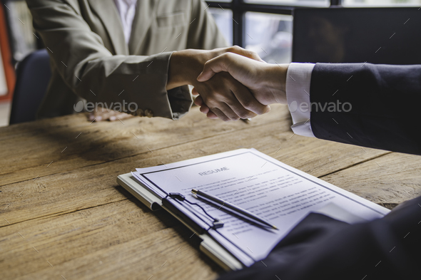Business people shaking hand after business signing contract and resume on desk in meeting room at c