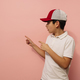 Young guy pointing aside in studio. - PhotoDune Item for Sale