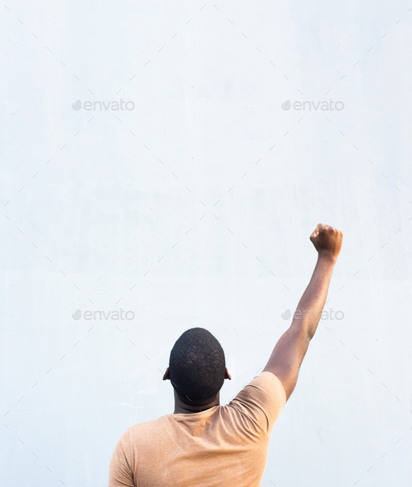 behind young black man with arm raised and fist pump in the air Stock ...