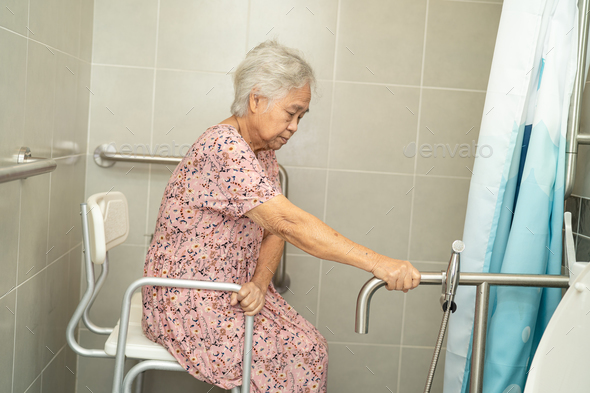 Asian elderly woman patient use toilet bathroom handle security in nursing hospital