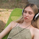 A girl in headphones lies in a sun lounger and meditates to the music - PhotoDune Item for Sale