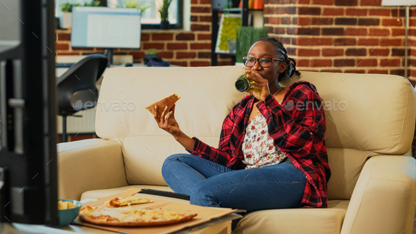 Happy woman eating pizza from delivery at home