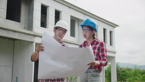 Two construction engineers meeting together in real estate building in safety Uniform.