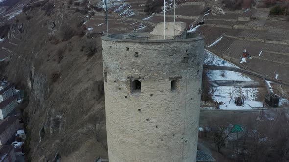 Drone flying away from tower of La Bâtiaz Castle and revealing the medieval structure alt