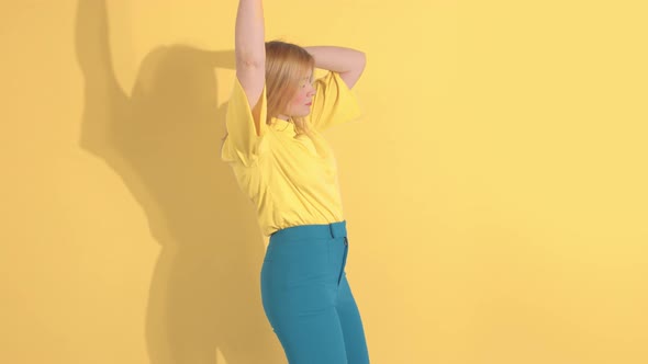 Young Woman in Bright Clothes on Bright Yellow Background in Studio