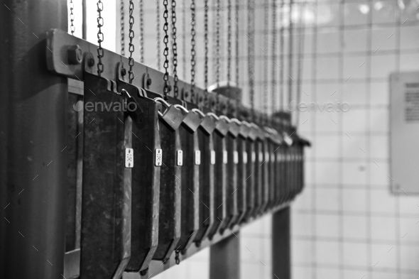Close-up view of an aged metal jail cell with a chain - grayscale