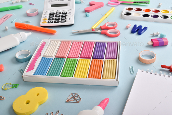 Pink school supplies stand on a blue background. Stock Photo by