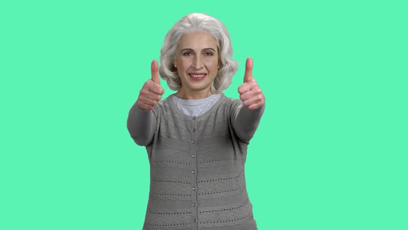 Smiling Mature Woman Giving Two Thumbs Up. alt