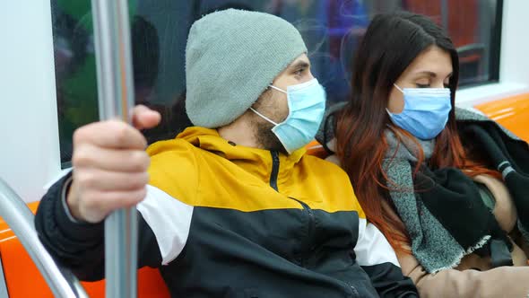public transport during the pandemic - young couple wearing mask on the subway alt