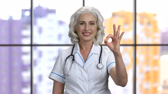 Old Senior Female Doctor Wearing Stethiscope and Showing Okay Gesture alt