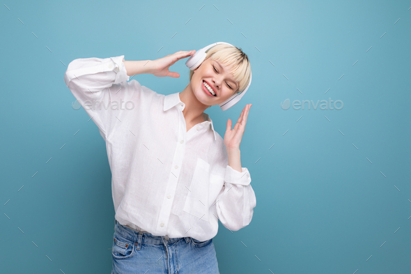 portrait of a stylish young pretty blond secretary woman dressed in a white blouse listening to