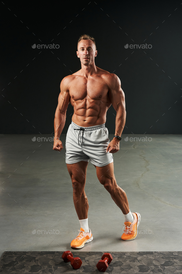 handsome caucasian athlete bodybuilder with perfect body stands in full ...