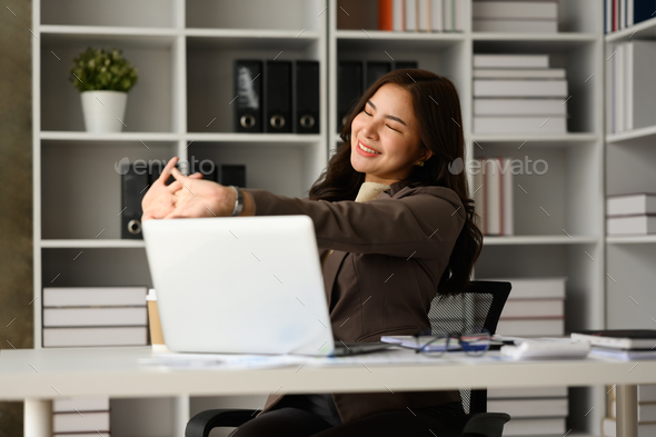 Calm young woman office worker feeling stress free relief and looking through window.