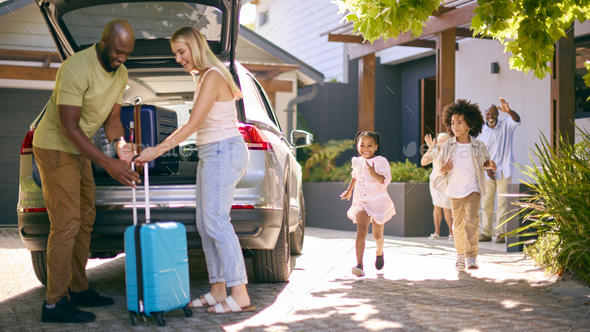 Family Loading Car And Saying Goodbye After Visit To Grandparents