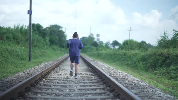 Indian Kid Running on the Railway Track in the Himalayan Range of India Greenery in the Background