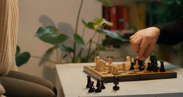 People Play Chess Game at Home