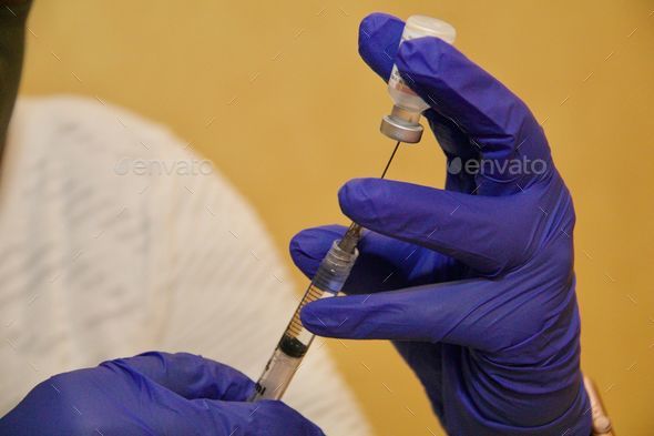 Doctor injecting with hypodermic needle