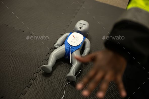 Classroom of students learning the basics of first aid with a doll