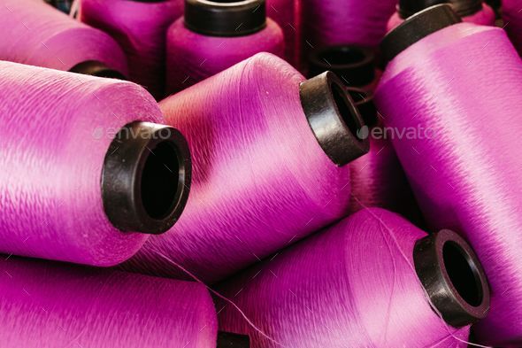 High-angle vertical shot of an organized display of colorful pink thread  spools Stock Photo by wirestock