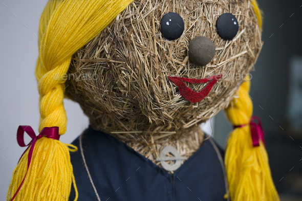 Face of a straw doll in ethnic folk style with yellow braids