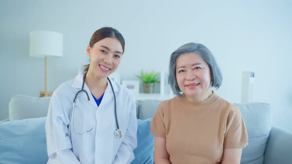 Portrait of Senior woman patient sit with physician doctor in house. alt