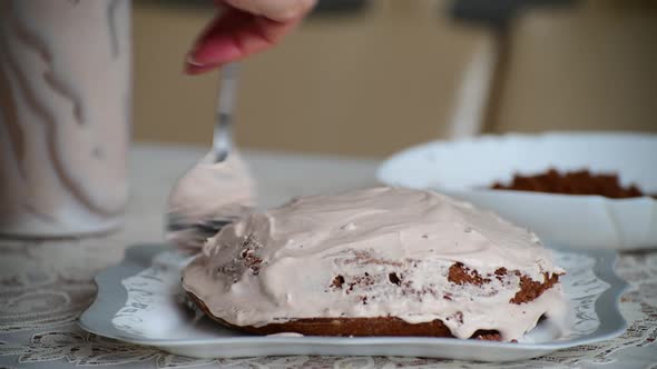 Woman Smears Sponge Cake with Cream