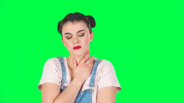Girl Got a Cold, Sore Throat and Head, Cough on Green Screen at Studio, Slow Motion. alt